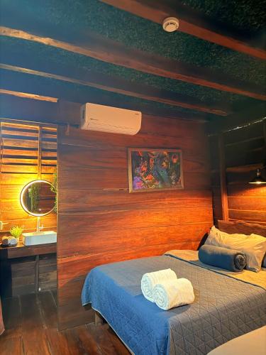 ein Schlafzimmer mit einem Bett und einer Holzwand in der Unterkunft Cabañas Alebrije in Celestún