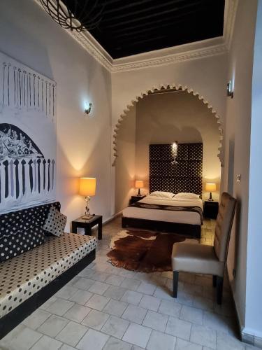 a bedroom with a bed and a couch in a room at Riad7 in Azemmour