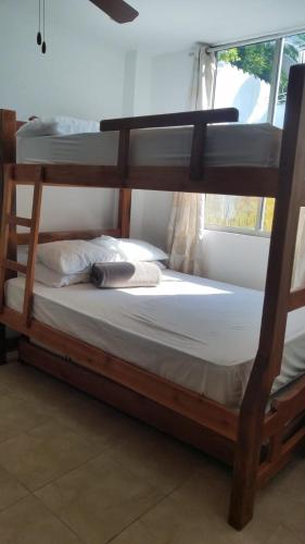 a bedroom with two bunk beds and a window at Apartamentos en coveñas in Coveñas