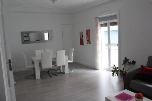 sala de estar con mesa y sillas blancas en Apartamento Luceros, en Alicante