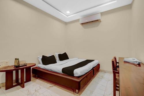 a bed in a room with a table and a bed sidx sidx sidx at HOTEL O INNORA in Raipur