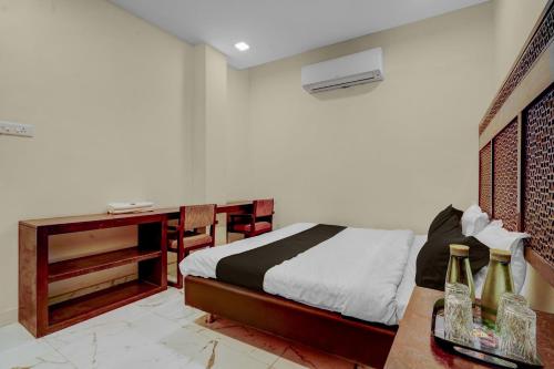 a bedroom with a bed and a table with bottles on it at HOTEL O INNORA in Raipur