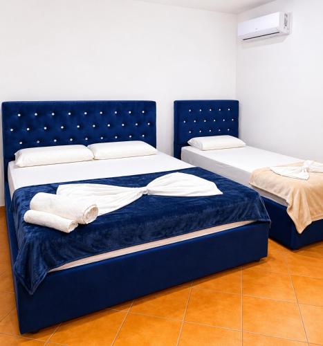 two beds in a room with towels on them at Villa Sofia in Durrës