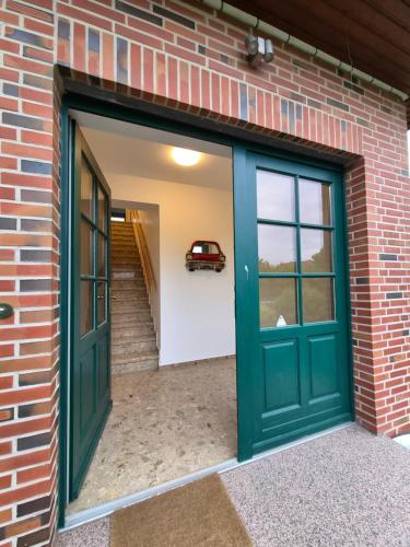 a garage with a green door and a car on the wall at Wohnung Ton Strand in Fehmarn