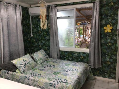 a bedroom with a bed and a window at Tureva lodge in Tiputa