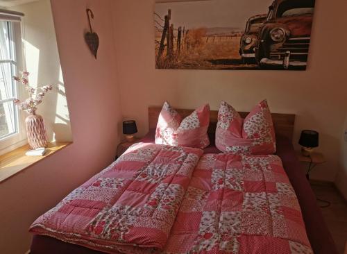 a bedroom with a bed with a red and white quilt at Haus Sonnenschein in Bad Bertrich