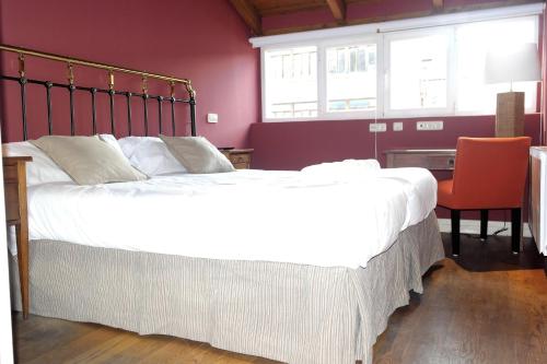 a bedroom with a large bed and a desk with a chair at Hotel Cuéntame La Puebla in Burgos