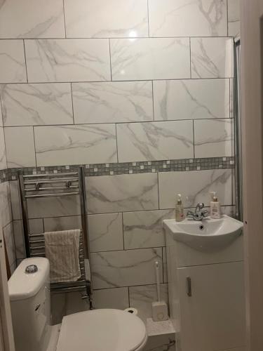 a white bathroom with a toilet and a sink at J S mentions in West Thurrock