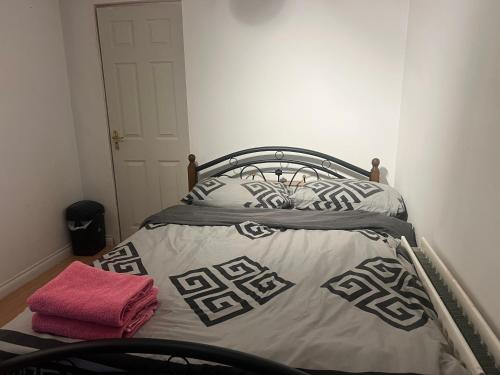 a bed in a bedroom with a pink towel on it at J S mentions in West Thurrock