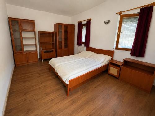 a bedroom with a bed and wooden floors at BLTN House in Balatonalmádi