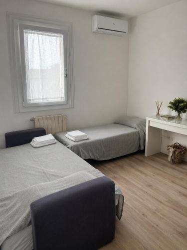 a bedroom with two beds and a desk and a window at Classense House in Classe