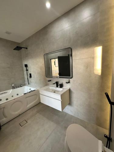 a bathroom with a sink and a tub and a mirror at TRIO Chalet 1 in Sowayma
