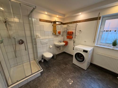 a bathroom with a shower and a washing machine at Ferienwohnung AARONA in Memmelsdorf