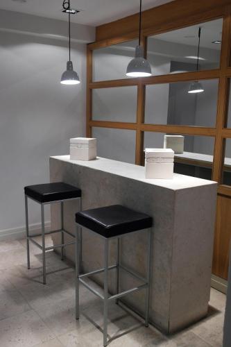 a counter with two stools and two lights at Hotel Cuéntame La Puebla in Burgos