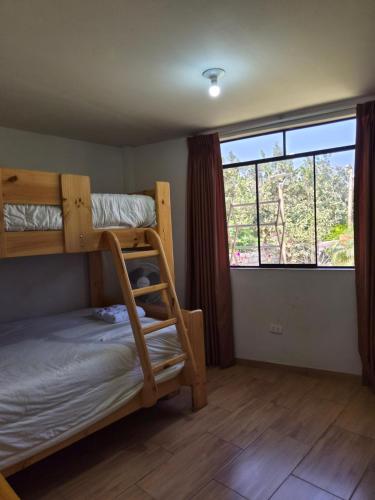 a bedroom with bunk beds and a large window at Bungalows Payancas de Tato in Barranca