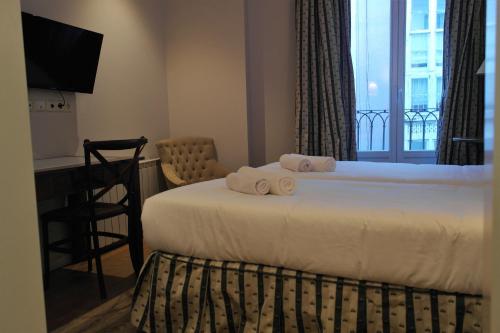 a hotel room with a bed with towels on it at Hotel Cuéntame La Puebla in Burgos