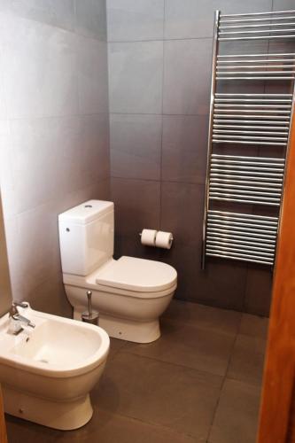 a bathroom with a toilet and a sink at Hotel Cuéntame La Puebla in Burgos