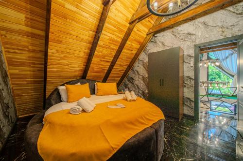a bedroom with a large bed with towels on it at Qafqaz Cabana Chalet in Gabala