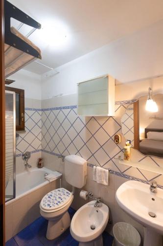 a bathroom with a toilet and a sink and a tub at Happy Hen Garden Suite in Bivigliano