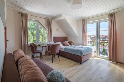 a bedroom with a bed and a table with a couch at Villa Baltica in Łeba