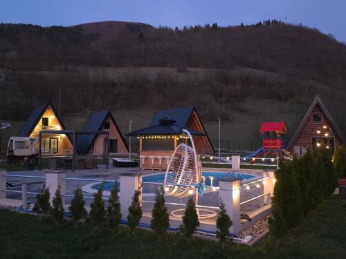 a resort with a pool and a ferris wheel at night at Etno Selo Relax in Šipovo