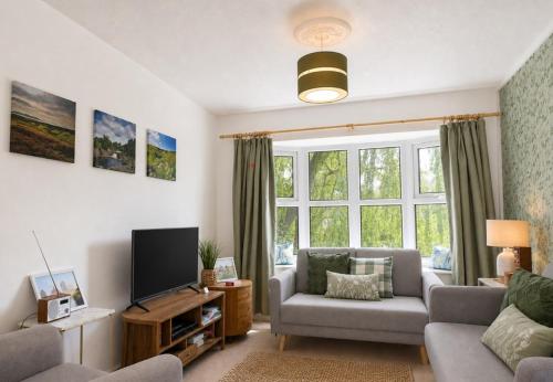 a living room with a couch and a tv at Willow View Streamside Retreat near Kynren Durham in Newton Aycliffe