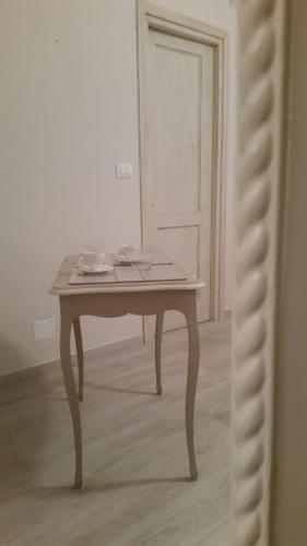 a table in the middle of a room with a door at Novecento Charming Room in Avigliana