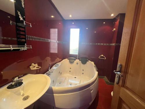 a bathroom with a tub and a sink at Villa ETAHIRI in Marrakesh