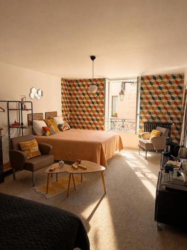 a bedroom with a bed and a couch and a table at ROOMS HOME CSM Suites privees élégantes entre Reims et Disneyland Paris 1 à 8 personnes in Charly-sur-Marne