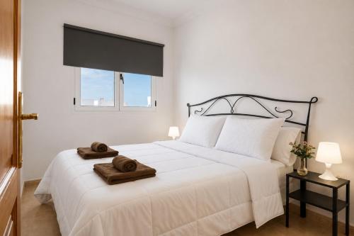 a bedroom with a white bed with a towel on it at Ganivet Home in Arrecife