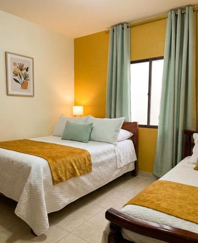 a hotel room with two beds and a window at Hotel Dorado Jardín in Jardin