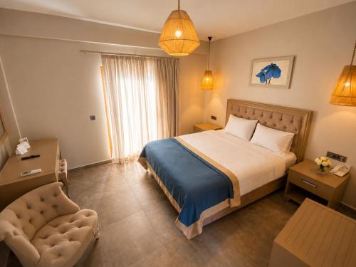 a hotel room with a bed and a chair at Mercans Bodrum Beach Hotel in Bodrum City