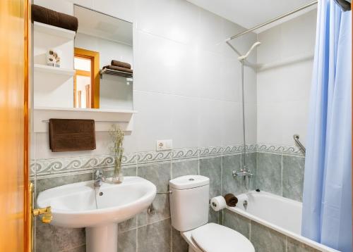 a bathroom with a sink and a toilet and a tub at Ganivet Home in Arrecife