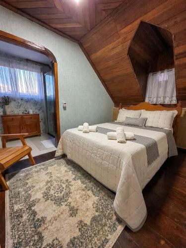 a bedroom with a large bed and a wooden ceiling at Casa Astral in Chapada dos Guimarães
