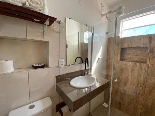 a bathroom with a sink and a toilet and a shower at Kailua apartamentos e suítes in Porto De Galinhas