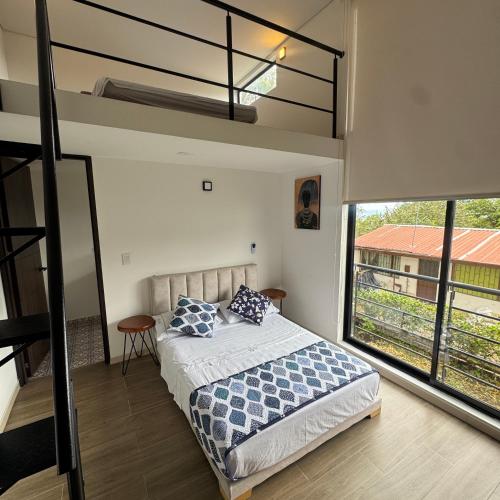 a bedroom with a bed and a large window at VILLA DEL ROSARIO in Tena