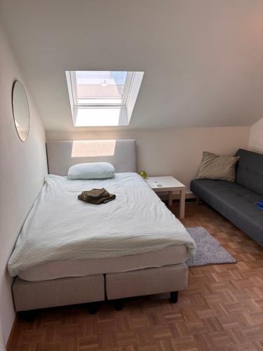 a bedroom with a bed with a window and a couch at Selma hosts Tomorrowland 2026 in Duffel