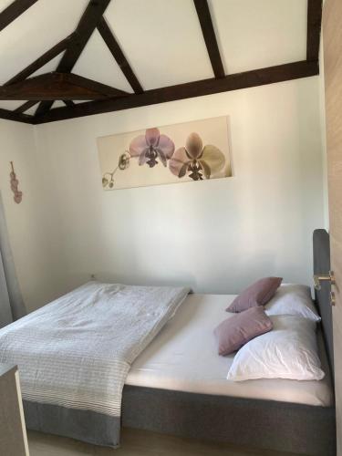 a bedroom with a bed with two flowers on the wall at Apartment Eleni in Šibenik