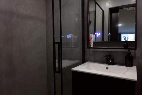 ein Badezimmer mit einem weißen Waschbecken und einem Spiegel in der Unterkunft Ūgļa in Puša