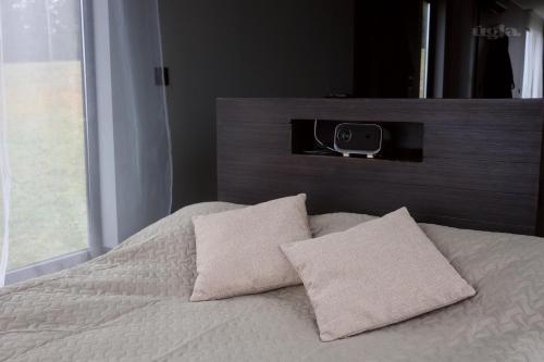 ein Schlafzimmer mit einem Bett und einem Lautsprecher an der Wand in der Unterkunft Ūgļa in Puša