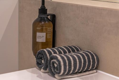 a bottle of alcohol next to two towels on a counter at The Stables Motel in Bulls