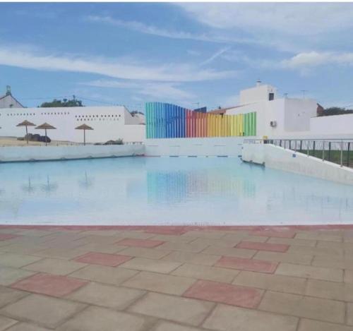 a swimming pool with a colorful fence and buildings at A Casinha in Portel