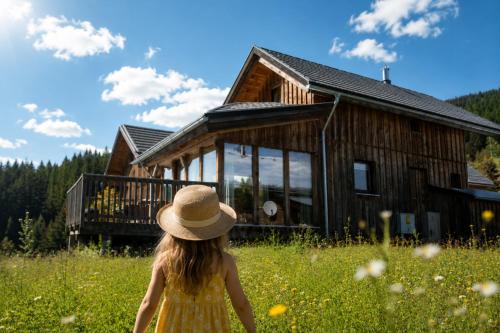 a little girl in a yellow dress in front of a cabin at Chalet SCHNEEHASE 10min - Kreischberg in Stadl an der Mur