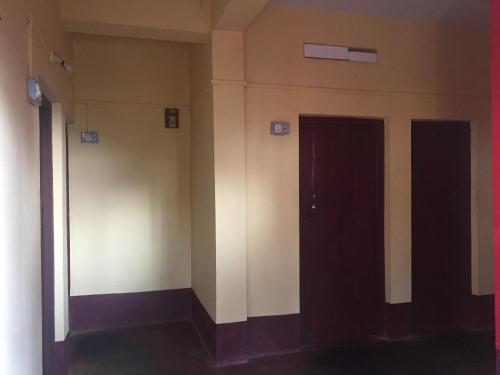 an empty hallway with two doors in a building at Nimmu Guest House & Restaurant Gokarna in Gokarna