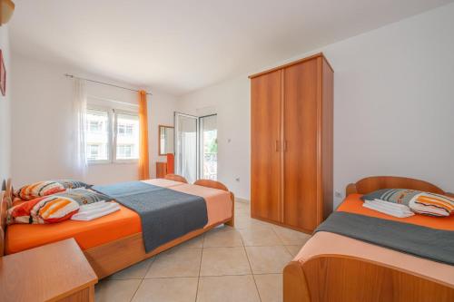 a bedroom with two beds and a cabinet at Apartmani Aleks in Budva