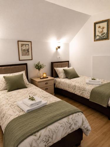 a bedroom with two beds with towels on them at Apartmani Hena in Sjenica