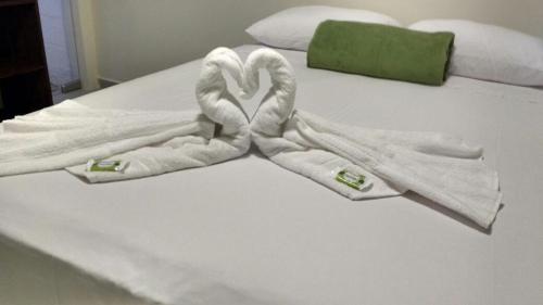 a bed with two swans made out of towels at Hotel Pousada Rio Mar in Ubatuba