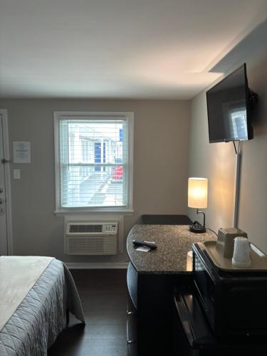 a hotel room with a bed and a window at Shore Point Motel in Point Pleasant Beach