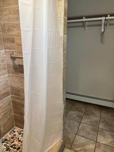 a shower with a white shower curtain in a bathroom at Shore Point Motel in Point Pleasant Beach