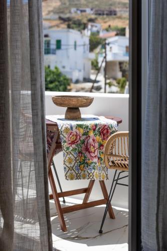 a table and a chair sitting on a balcony at Elaia Home luxury village apartment for two Naxos in Galini